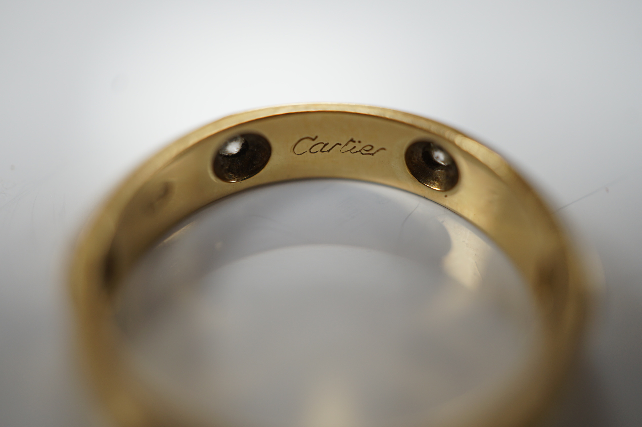 A modern Cartier 18ct gold and six stone diamond set band, signed and numbered 441404, size L, gross weight 3.3 grams, no box or certificate.